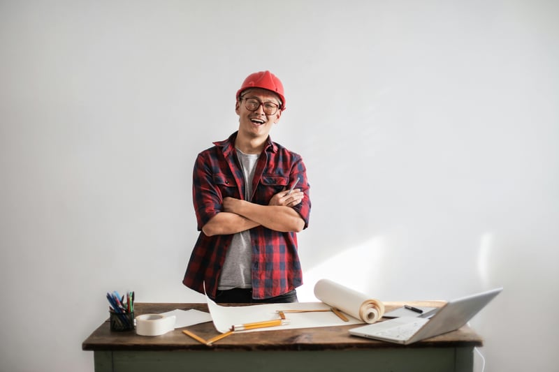 Contractor standing behind table wearing hard hat